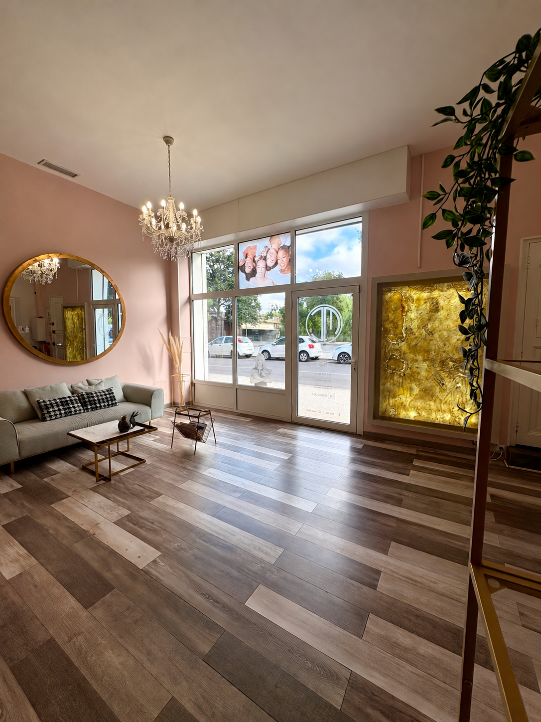 Accueil Mia Beauty avec canapé, miroir doré, lustre et grande entrée vitrée
