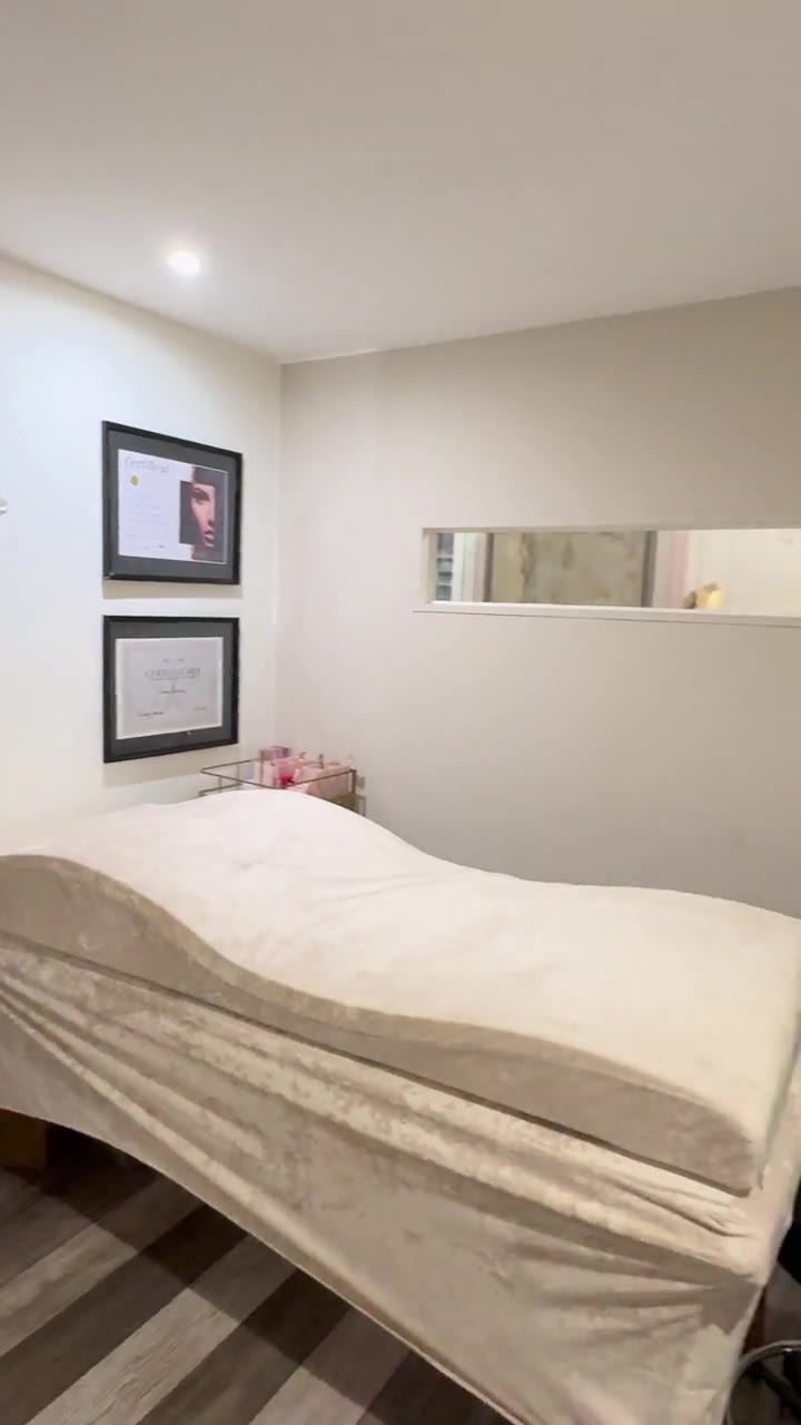 Cabine esthétique beige avec table de soin et miroir mural