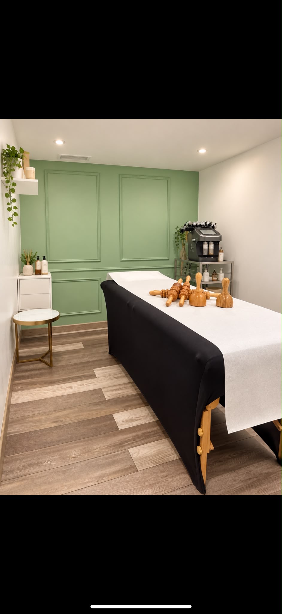 Cabine esthétique au mur vert à moulures, avec table de soin