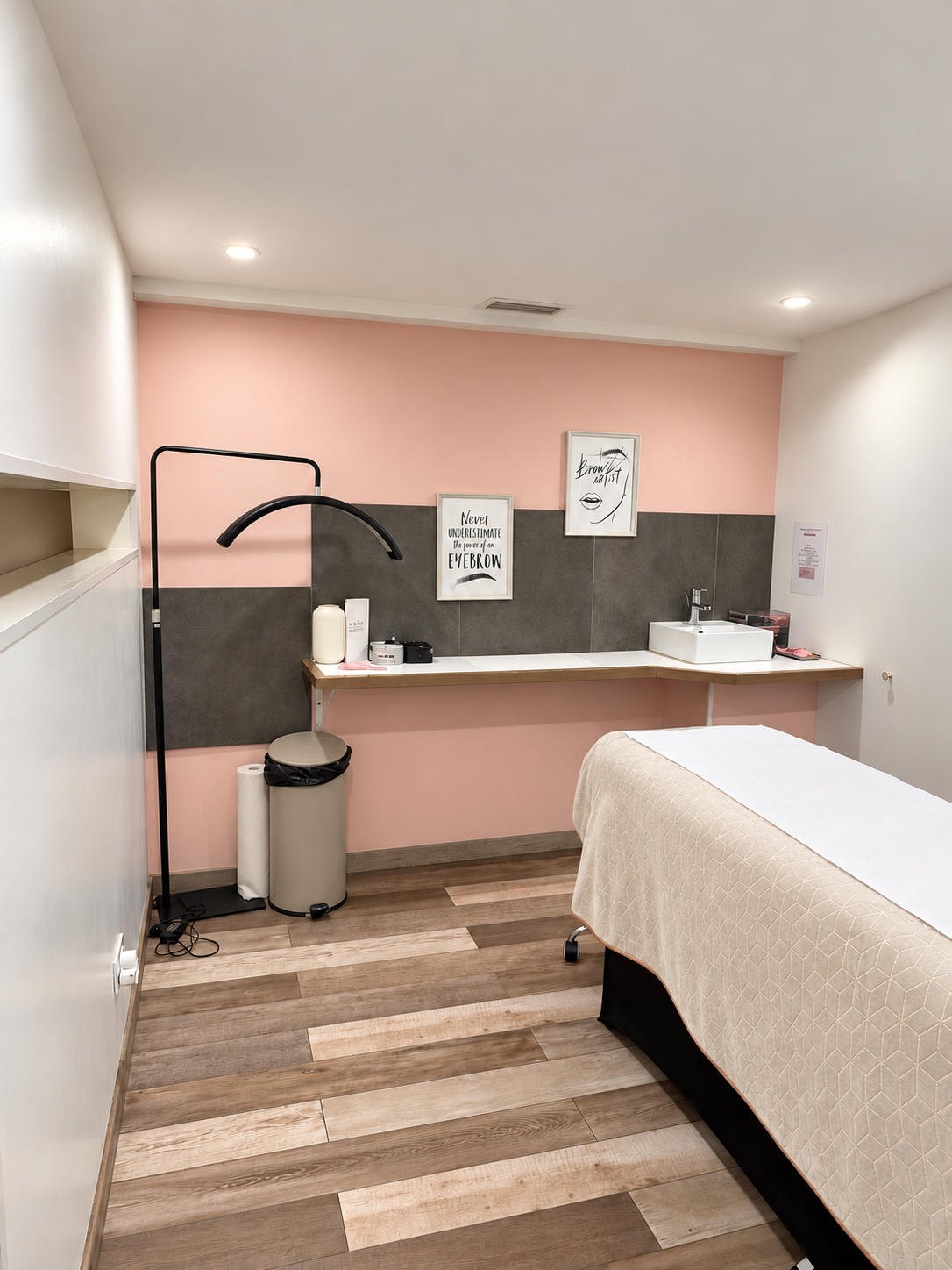 Cabine de soin rose avec table de soin, éclairage et point d’eau